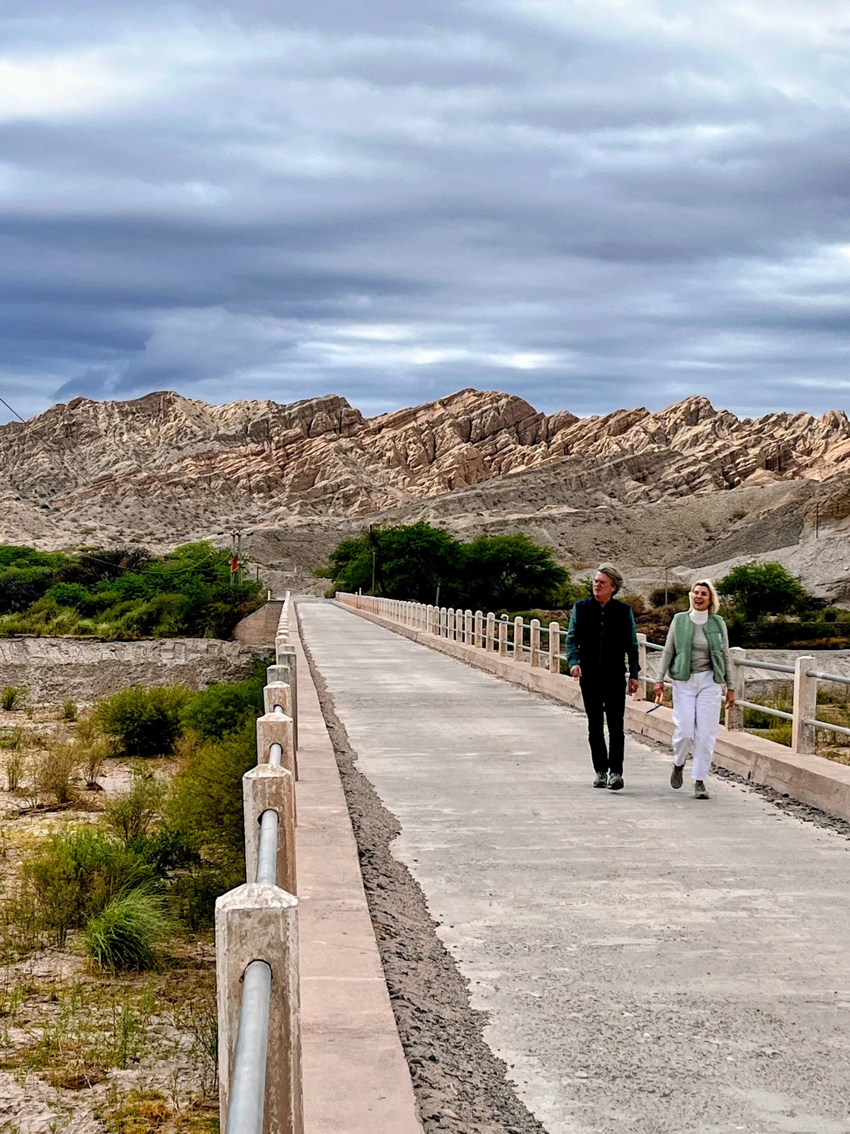 Two travellers walking across a bridge in the Calchaquí Valleys