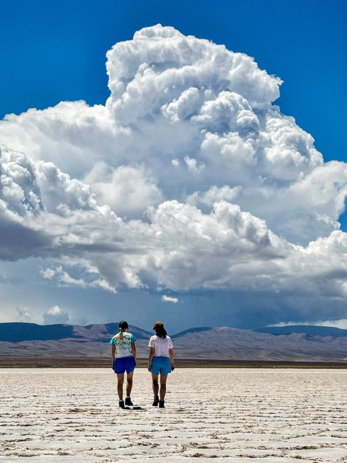 Walking on the Salinas Grandes under a summer storm cloud